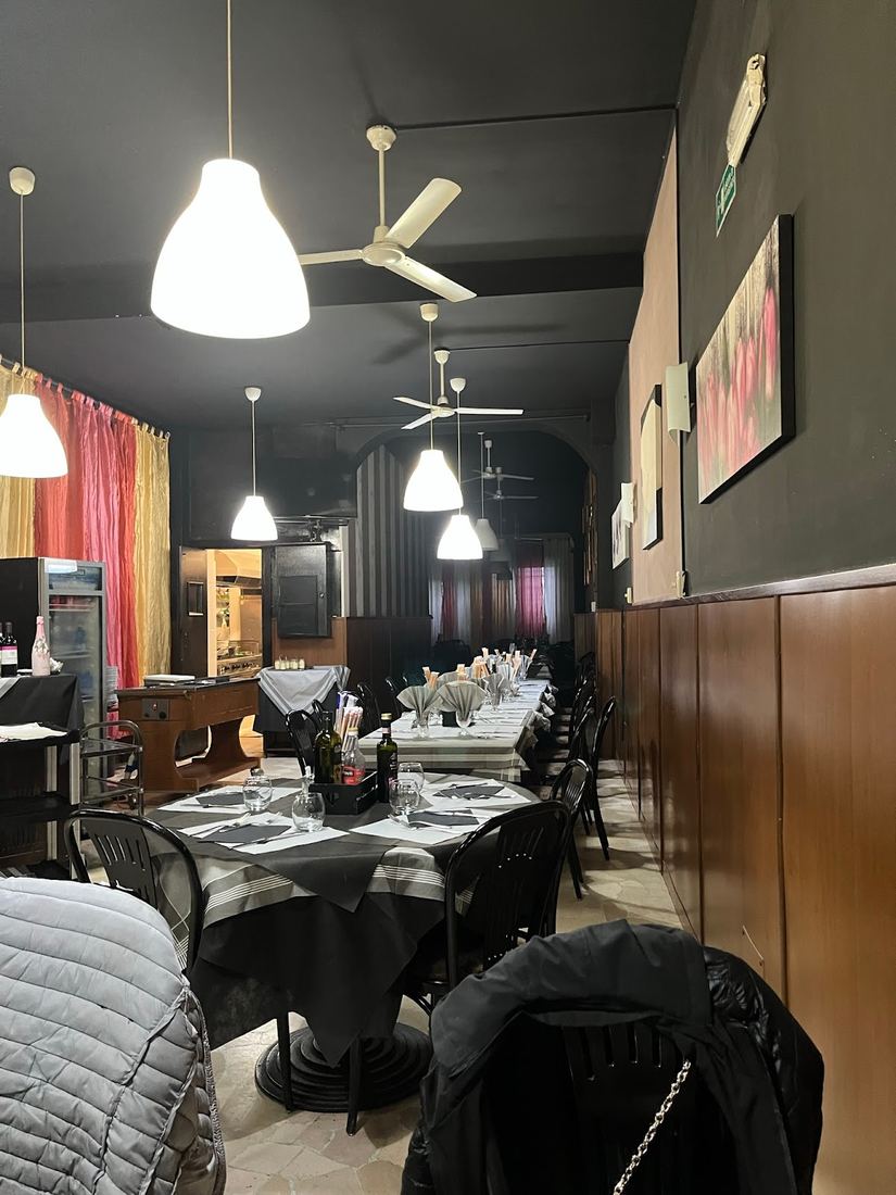 La sala di sera con le lampade accese e le tende colorate in fondo