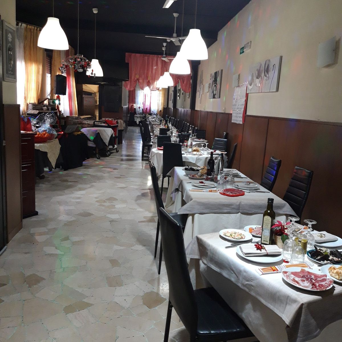 Tavoli in fila con gli antipasti già serviti, apparecchiati per una festa